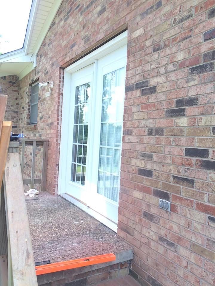 New French doors installed on a brick home