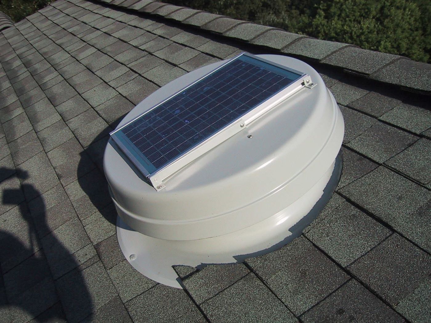 Solar-powered attic fan installed on a shingle roof