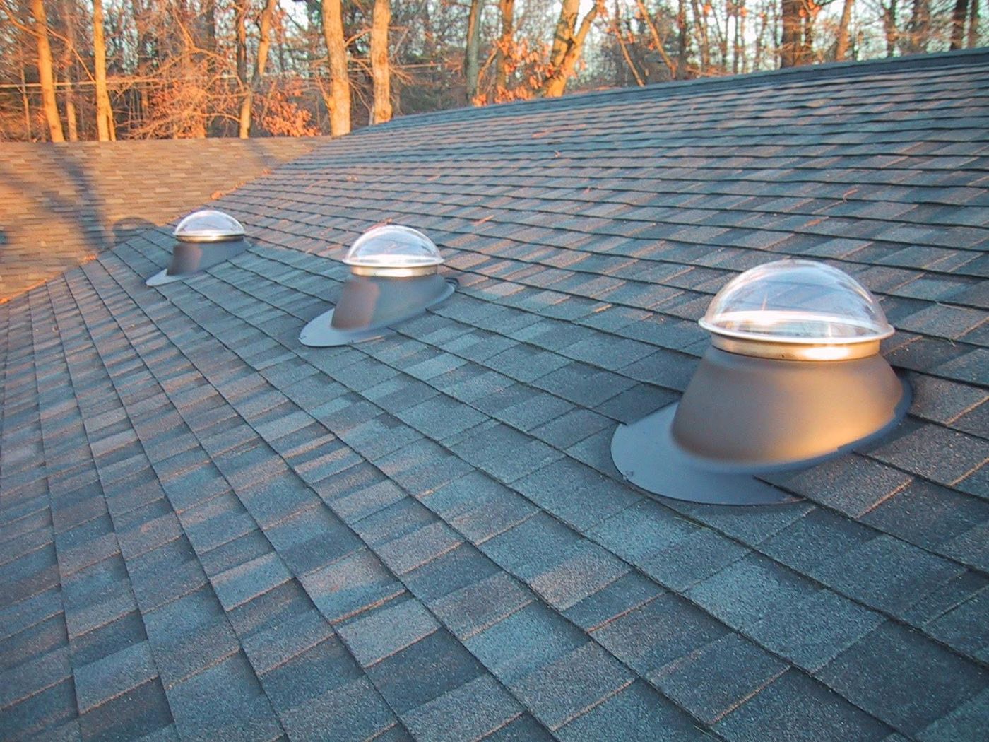 Three tubular skylights installed on a shingle roof