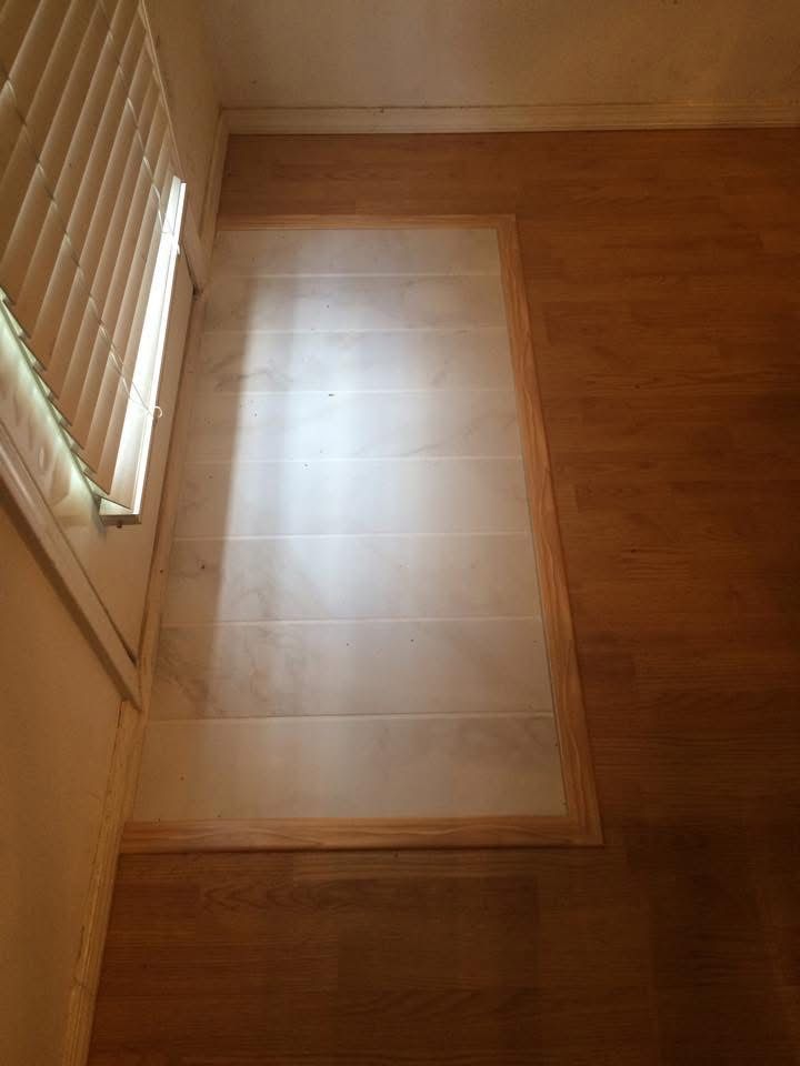 Finished tile inlay with wood trim by a window